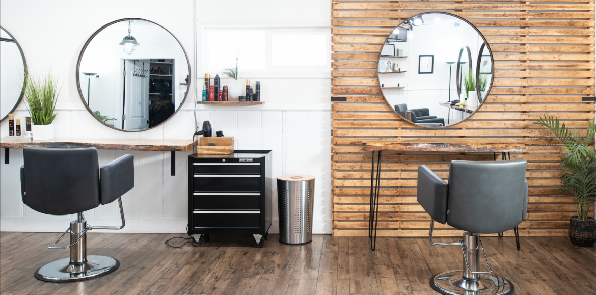 Ivy + Oak salon stations with white and wood walls reflected back in circle mirrors